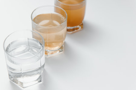 Filter system for water treatment with glasses of clean and dirty water on bright background.の写真素材