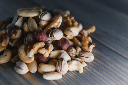 mixed nuts in a bowl on wooden table, top view with copy space
