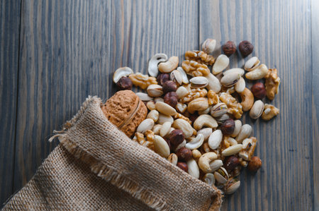 mixed nuts in a bowl on wooden table, top view with copy spaceの写真素材