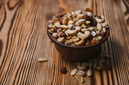 mixed nuts in a bowl on wooden table, top view with copy spaceの写真素材