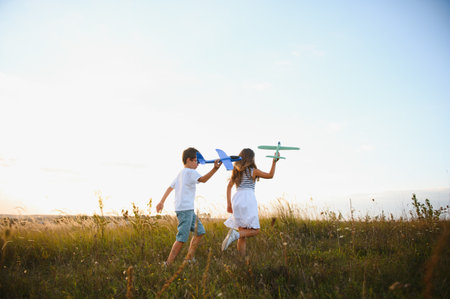 children play toy airplane. happy childhood concept. children dream of flying and becoming a pilotの写真素材