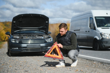 Man with broken car in the middle of the roadの写真素材