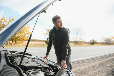 Man checking his broke down car.の写真素材