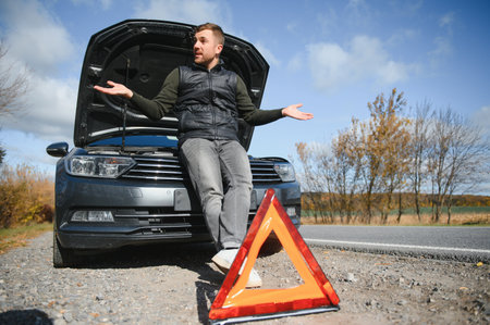 A young man with a black car that broke down on the road,copy spaceの写真素材