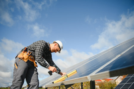 Professional worker installing solar panels on the metal construction, using different equipment,...