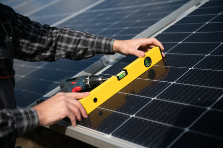 Professional worker installing solar panels on the metal construction, using different equipment,...