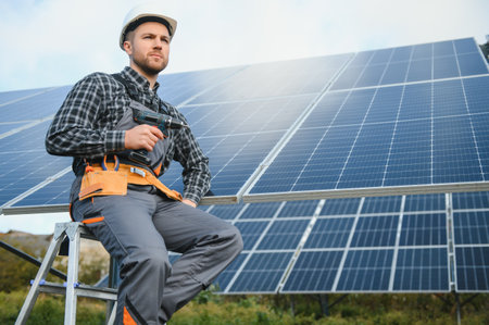 Professional worker installing solar panels on the metal construction, using different equipment, wearing helmet. Innovative solution for energy solving. use renewable resources. green energyの写真素材