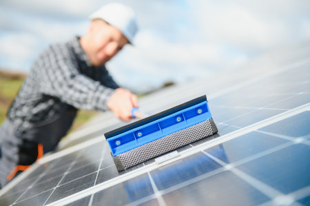 technician operating and cleaning solar panels at generating power of solar power plant technician in industry uniform on level of job description at industrial.の写真素材