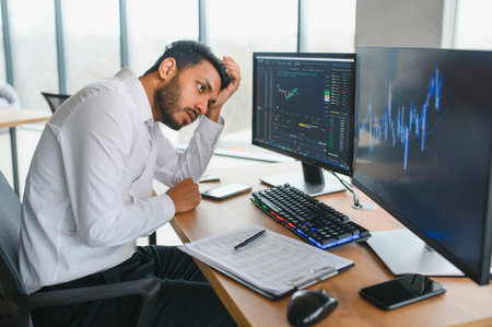 Portrait of a positive successful Indian or Arabian trader, stock market broker, Crypto charts on laptop screen.の写真素材