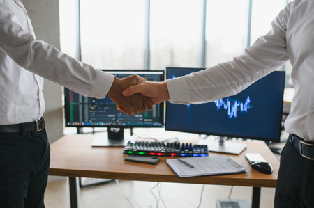 Hand shake between businessman on Trading graph on the cityscape at night and world map background,Business financial concept.の写真素材