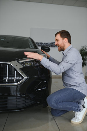 Young man is choosing a new vehicle in car dealership