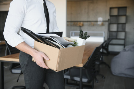 Close-up Of A Businessperson Carrying Cardboard Box During Office Meeting.の写真素材
