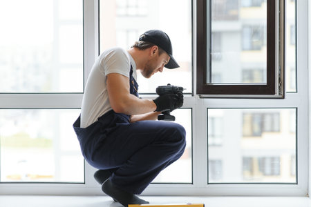 service man installing window with measure tape.の写真素材