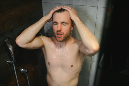 relaxing time.fresh shower concept.under good looking man is under water drops.