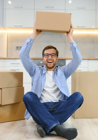 Young caucasian man at a new home with cardboard boxes.の写真素材