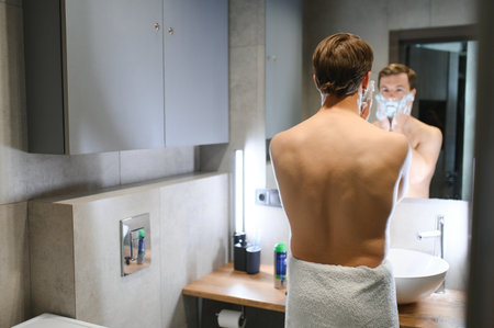 Mature handsome man shaving in front of mirror.の写真素材