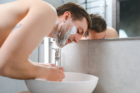 Mature handsome man shaving in front of mirror.の写真素材