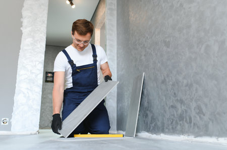 industrial worker, handyman installing big ceramic tiles.の写真素材