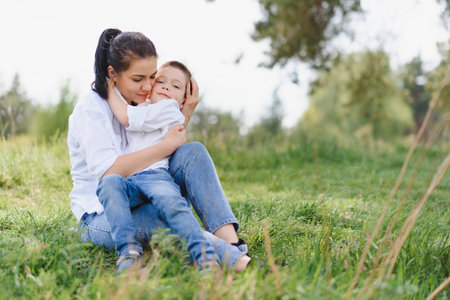 Stilish mother and handsome son having fun on the nature. happy family concept. Beauty nature scene with family outdoor lifestyle. Happy family resting together. Happiness in family life. mother's day.の写真素材