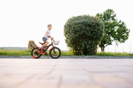Happy boy ride a bicycle in city park.の写真素材