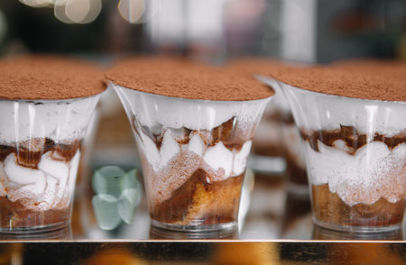 Traditional Italian dessert tiramisu in a glass on dessert table.