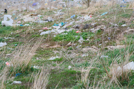 Ecological pollution of nature. Plastic bag tangled in plants against the backdrop of the mountains. global environmental pollution. Recycling, clearing the land from plastic debris.の写真素材