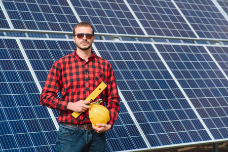 Young technician installing solar panels on factory roofの写真素材