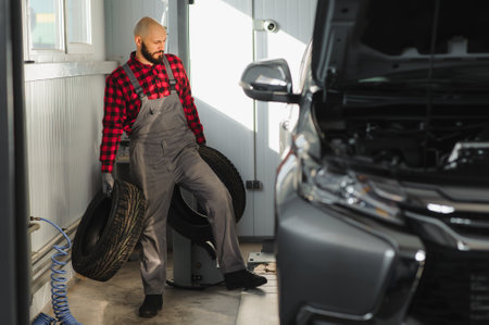Man repairing a car wheel in a garageの写真素材