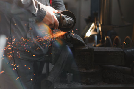 Worker cutting metal with grinder. Sparks while grinding iron