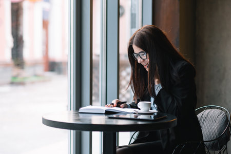Young businesswoman talking on the phone in coffee shop
