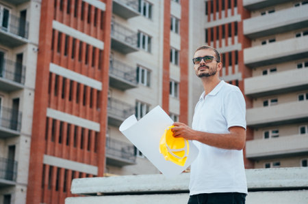 Portrait of an architect builder studying layout plan of the rooms, serious civil engineer working...