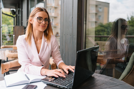 successful business woman with financial documents standing near a large window in a modern office.の写真素材