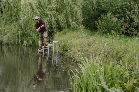 Fishing in river.A fisherman with a fishing rod on the river bank. Man fisherman catches a fish...