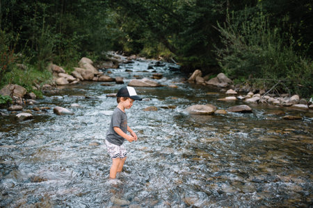 happy boy on a walk near the river in the mountains.の写真素材