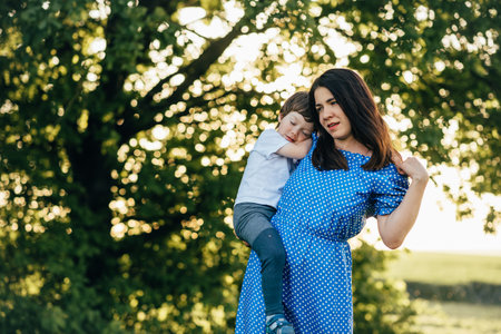 Stilish mother and handsome son having fun on the nature. happy family concept. Beauty nature scene with family outdoor lifestyle. Happy family resting together. Happiness in family life. mother's day.の写真素材