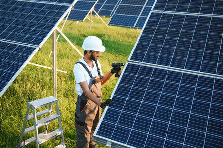An Indian worker installs solar panels. The concept of renewable energyの写真素材
