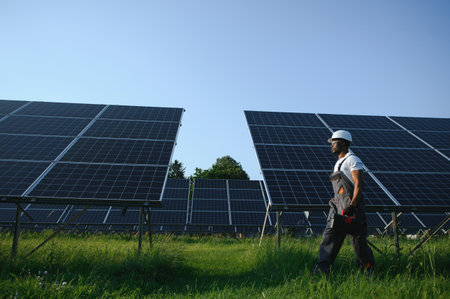 Portrait of african american electrician engineer in safety helmet and uniform installing solar panelsの写真素材