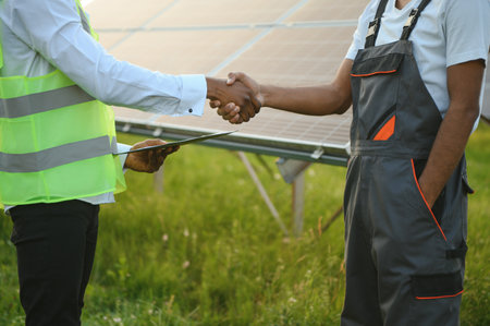 workers on installation of solar economical panels shake hands after work. The concept of solar panels.の写真素材