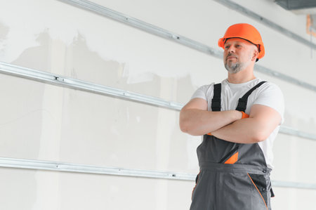 Portrait of a builder in the process of working on a construction site indoors.の写真素材