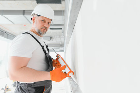 The builder fills the seams on the wall with sealed silicone.の写真素材