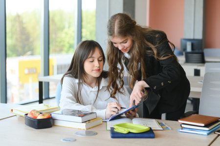Portrait of two girls at workplace with booksの写真素材