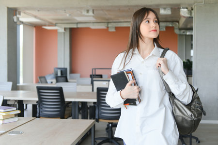 Portrait of a schoolgirl at school. She holds books in her hands. education conceptの写真素材