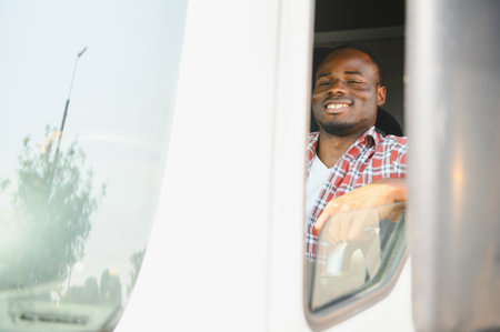 Young handsome African American man working in towing service and driving his truckの写真素材