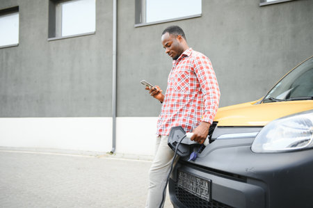 African American man charging his electric carの写真素材