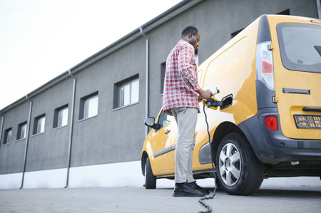 African American man charging his electric carの写真素材