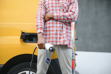 African American man charging his electric carの写真素材