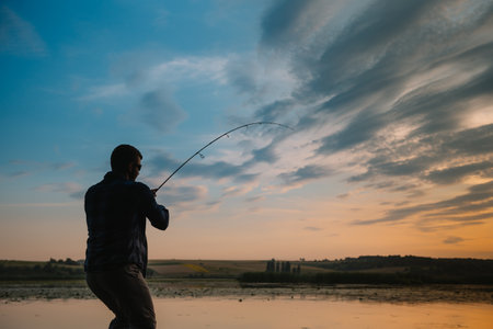 Fishing. spinning at sunset. silhouette of a fisherman