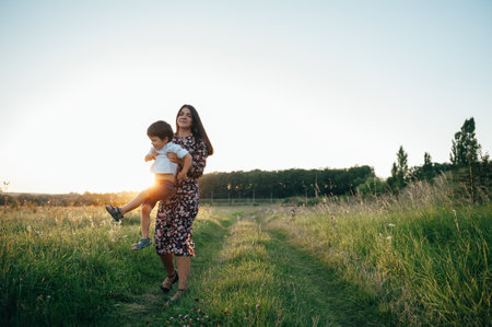 Stilish mother and handsome son having fun on the nature. happy family concept. Beauty nature scene with family outdoor lifestyle. Happy family resting together. Happiness in family life. mother's day.の写真素材