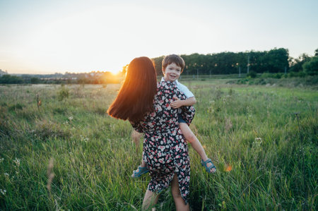 Stilish mother and handsome son having fun on the nature. happy family concept. Beauty nature scene with family outdoor lifestyle. Happy family resting together. Happiness in family life. mother's day.の写真素材