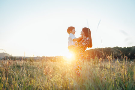 Stilish mother and handsome son having fun on the nature. happy family concept. Beauty nature scene with family outdoor lifestyle. Happy family resting together. Happiness in family life. mother's day.の写真素材